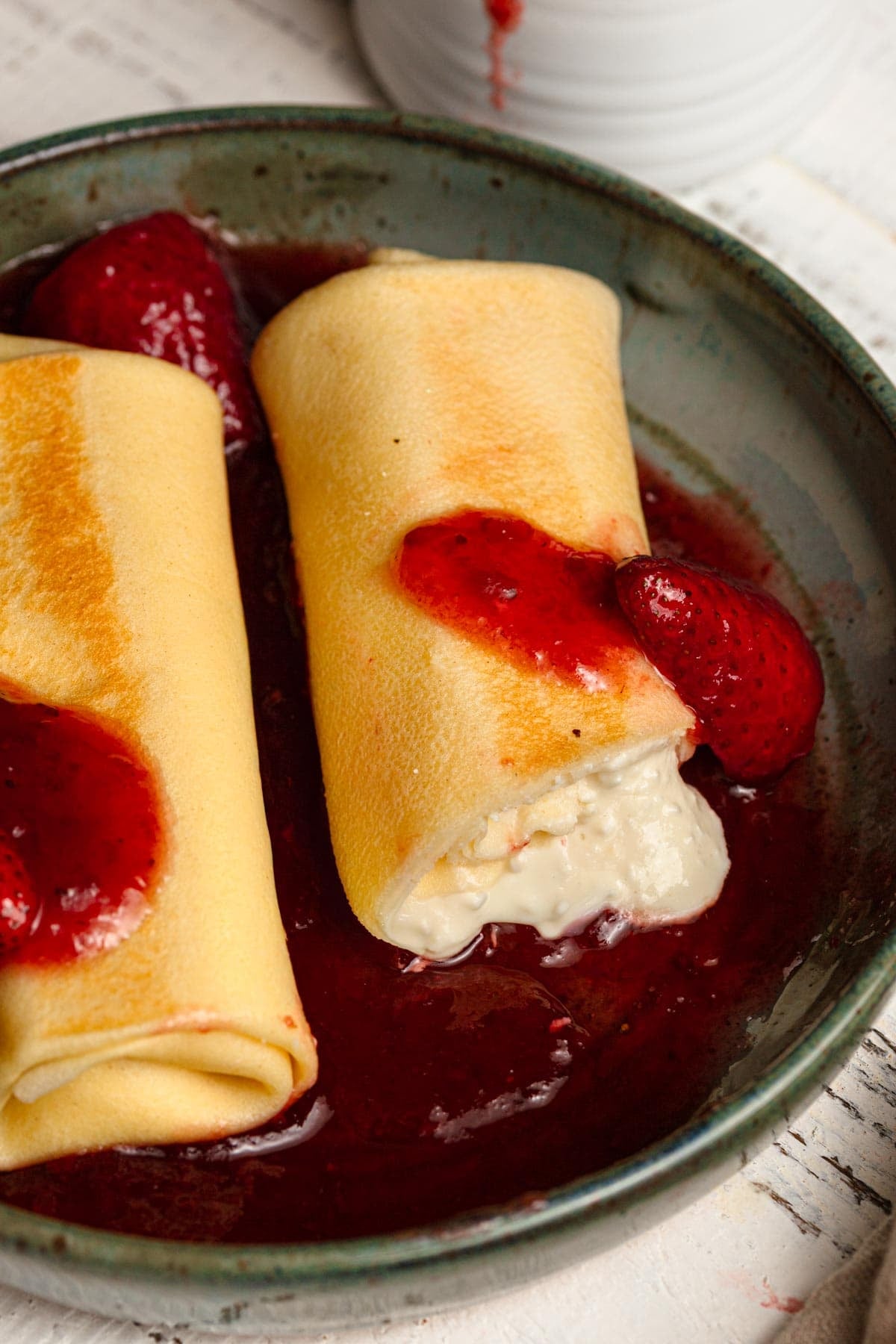 Cheese filled crepe topped with strawberries.