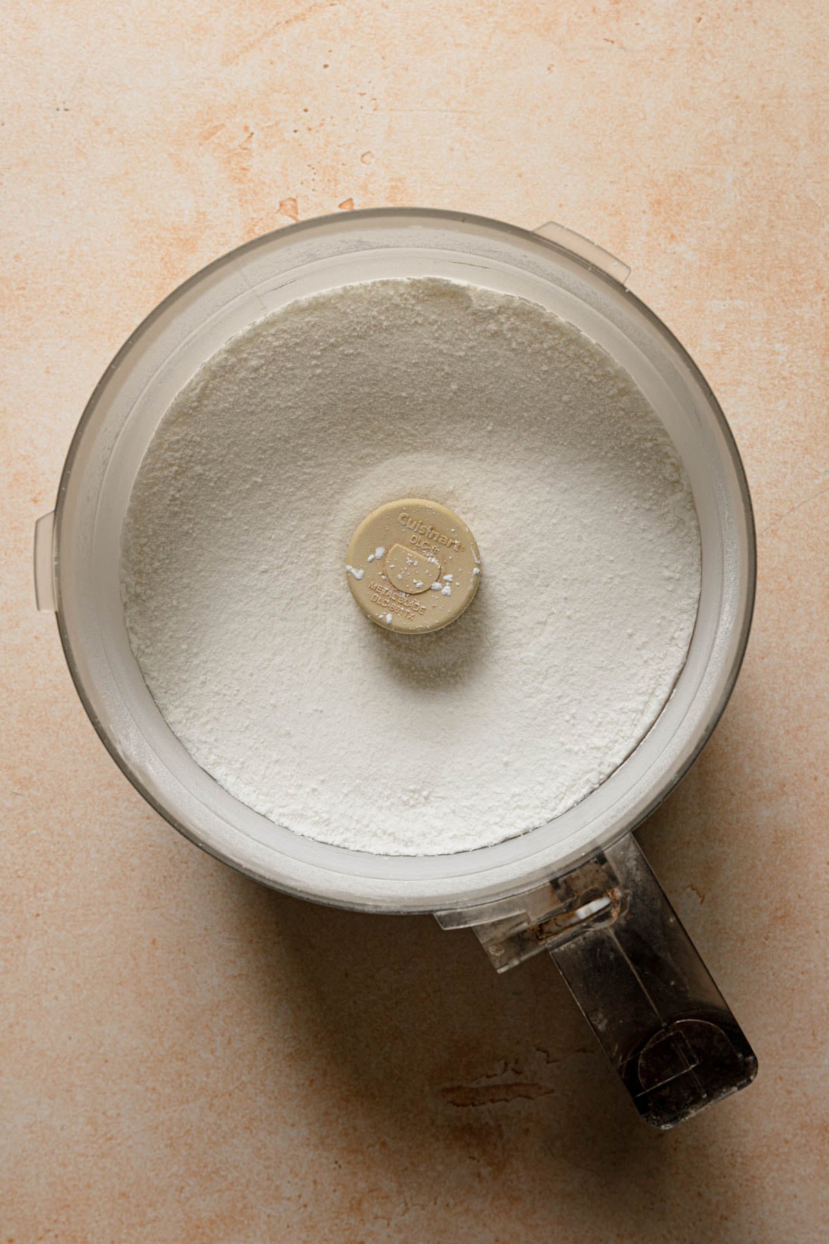 A food processor bowl with sugar.