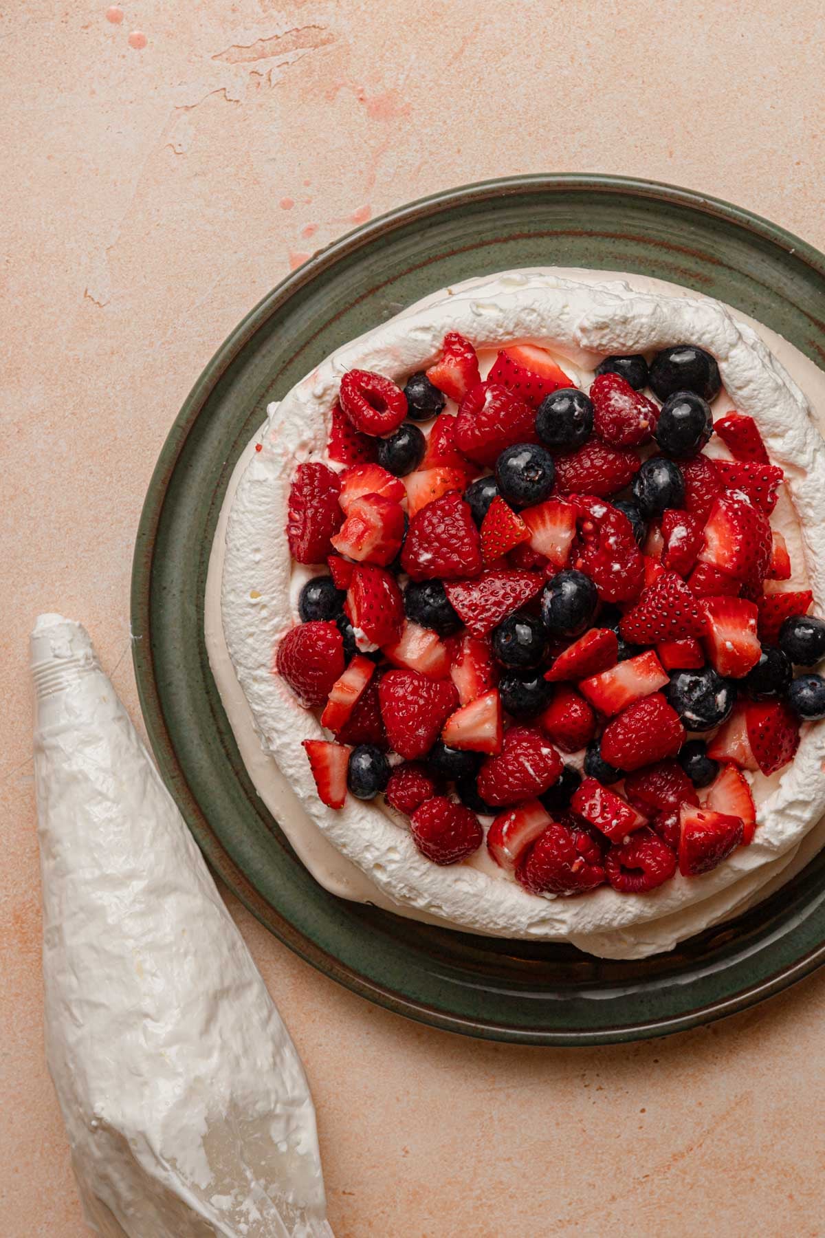 A meringue disk topped with cream and mixed berries.