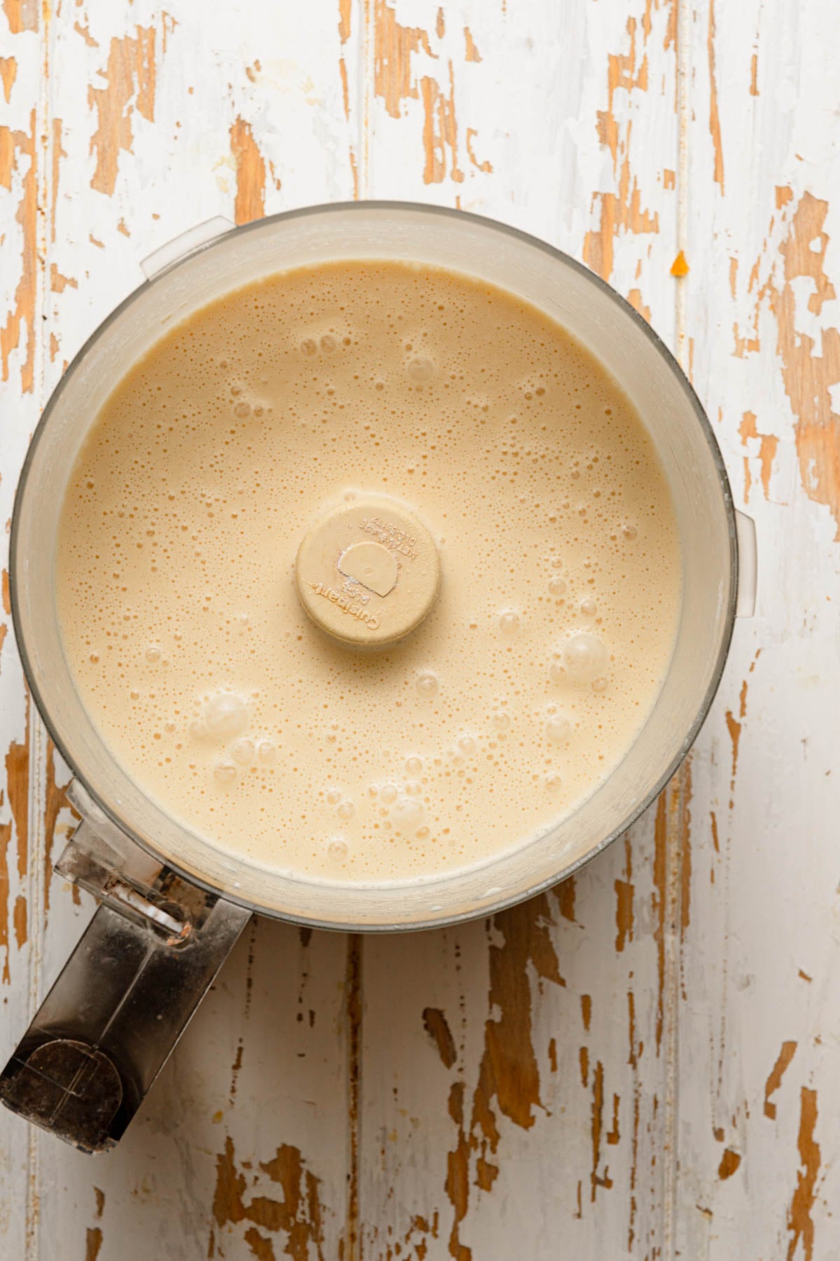 A food processor bowl with thin, liquid batter.