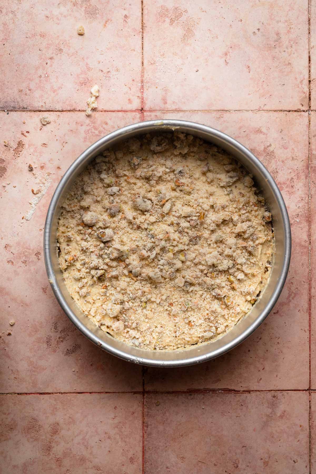 A pan with cake batter topped with streusel.
