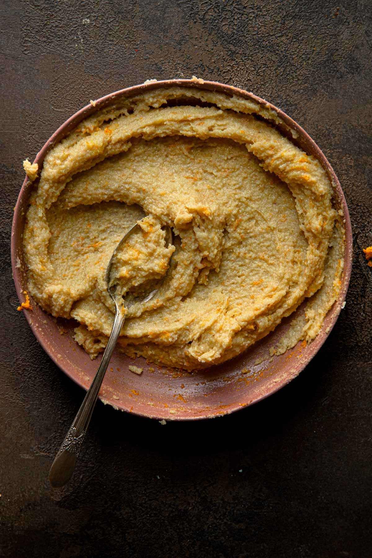 A bowl with smooth cream and a spoon. 