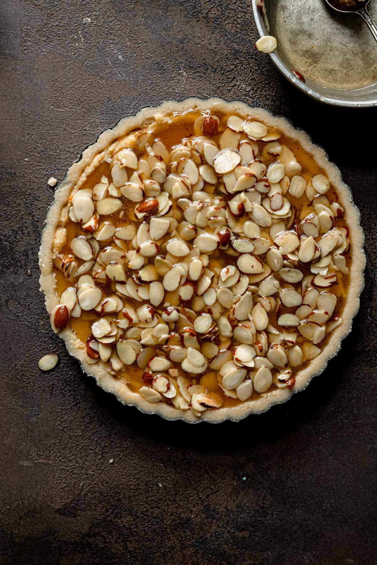 Unbaked tart topped with honey-almond topping.