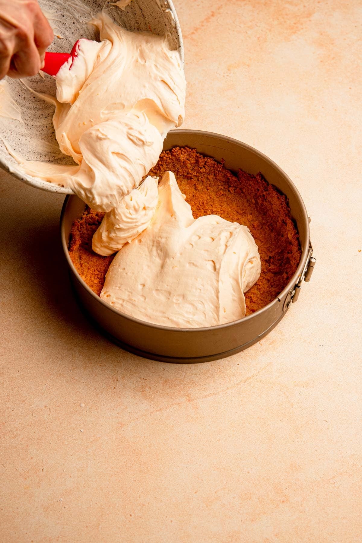 Topping cookie crumb with orange cheesecake filling.