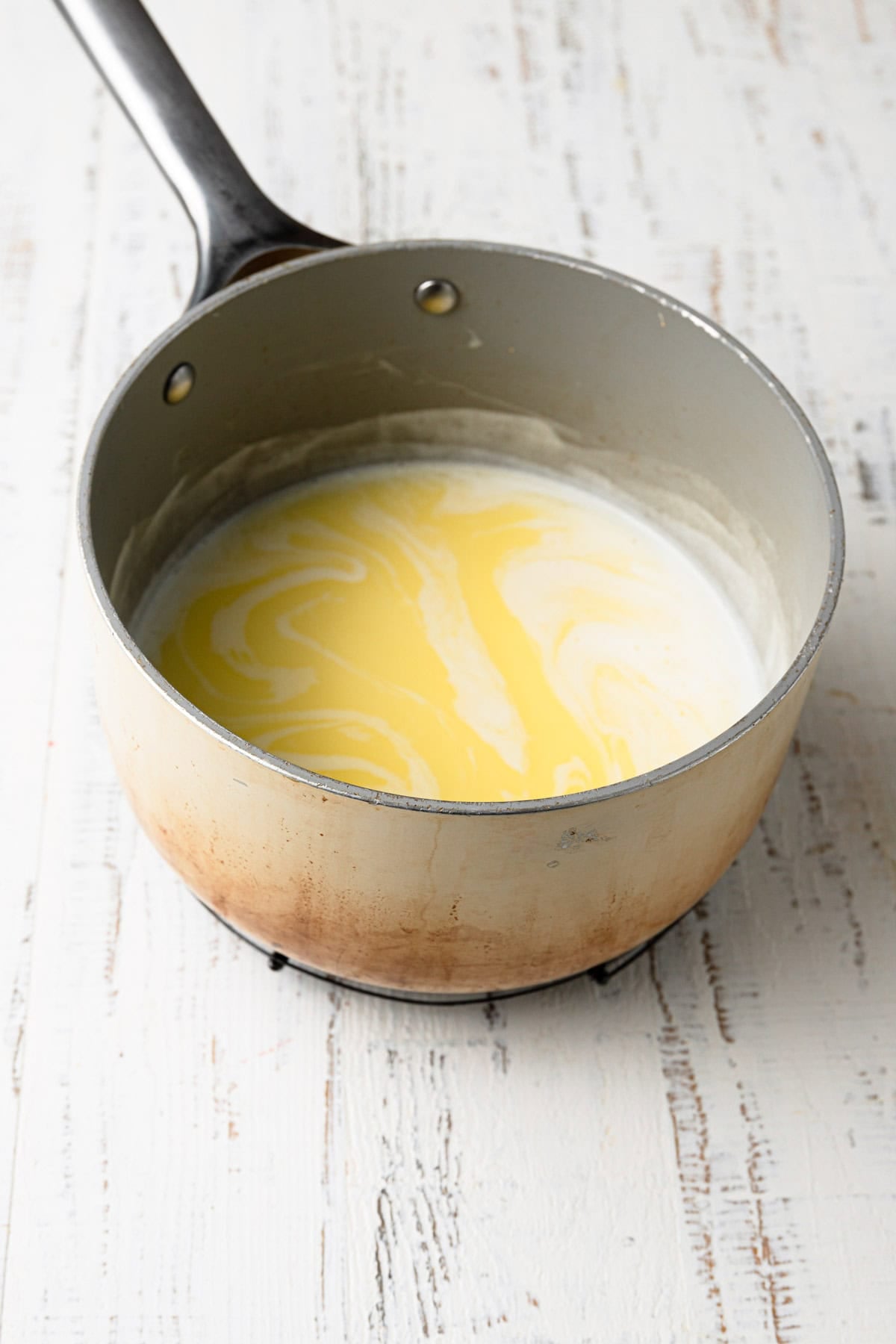 A saucepan with milk and melted butter.