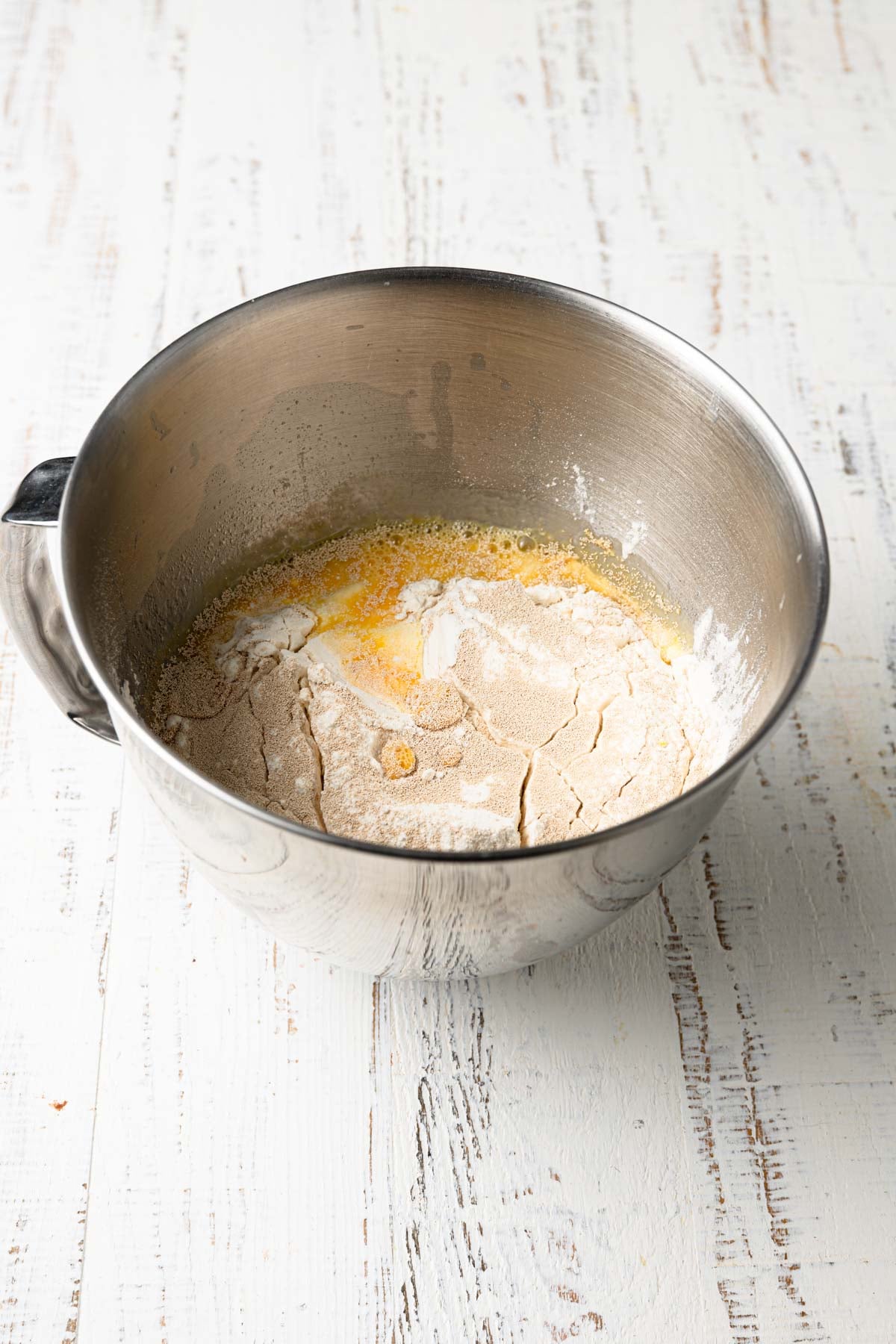 A mixing bowl with flour, yeast and eggs.