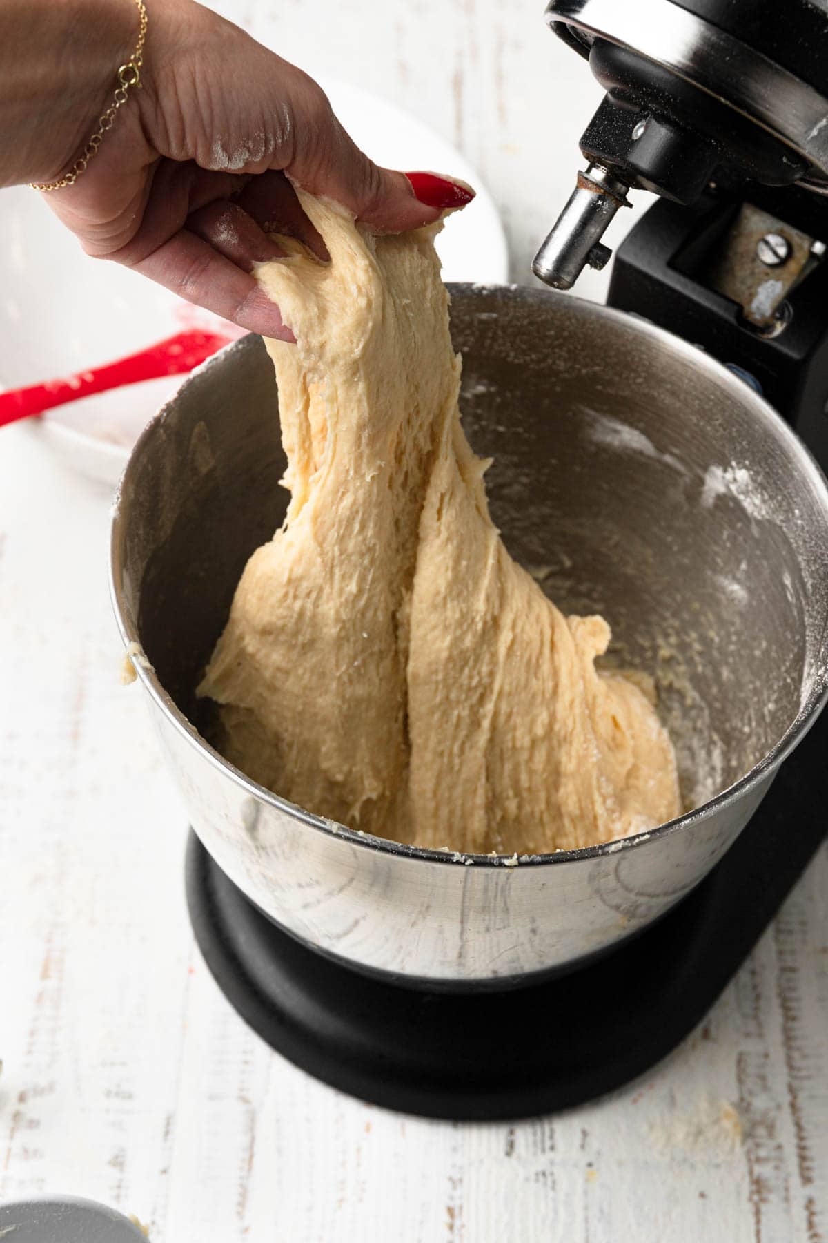 A hand pulling dough.