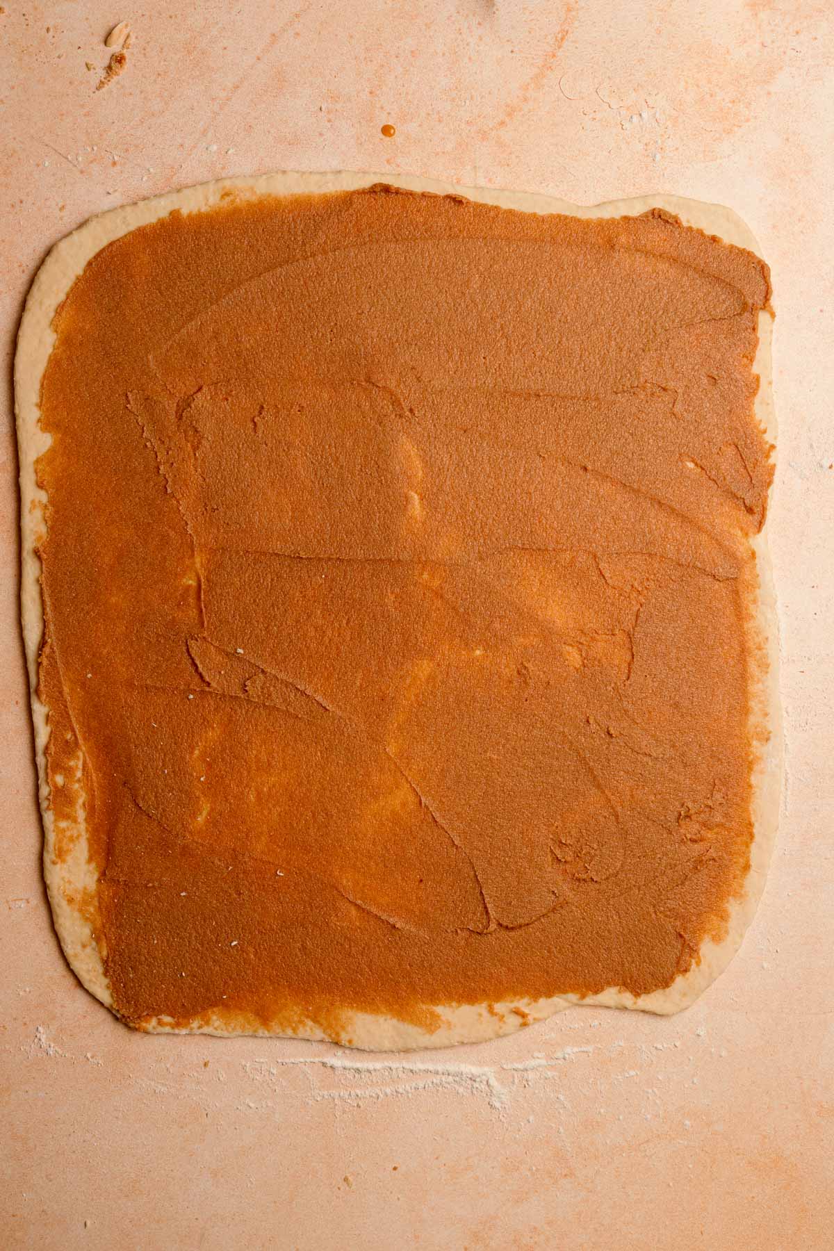 A rolled dough topped with cinnamon filling.