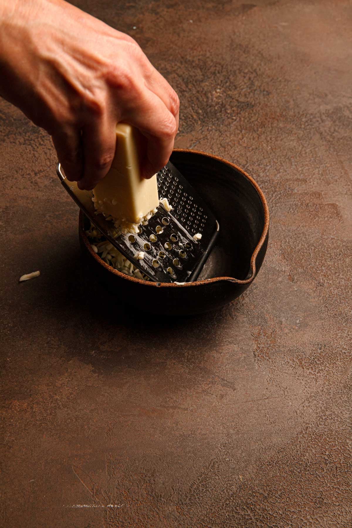 Grating butter using a vegetable grater.
