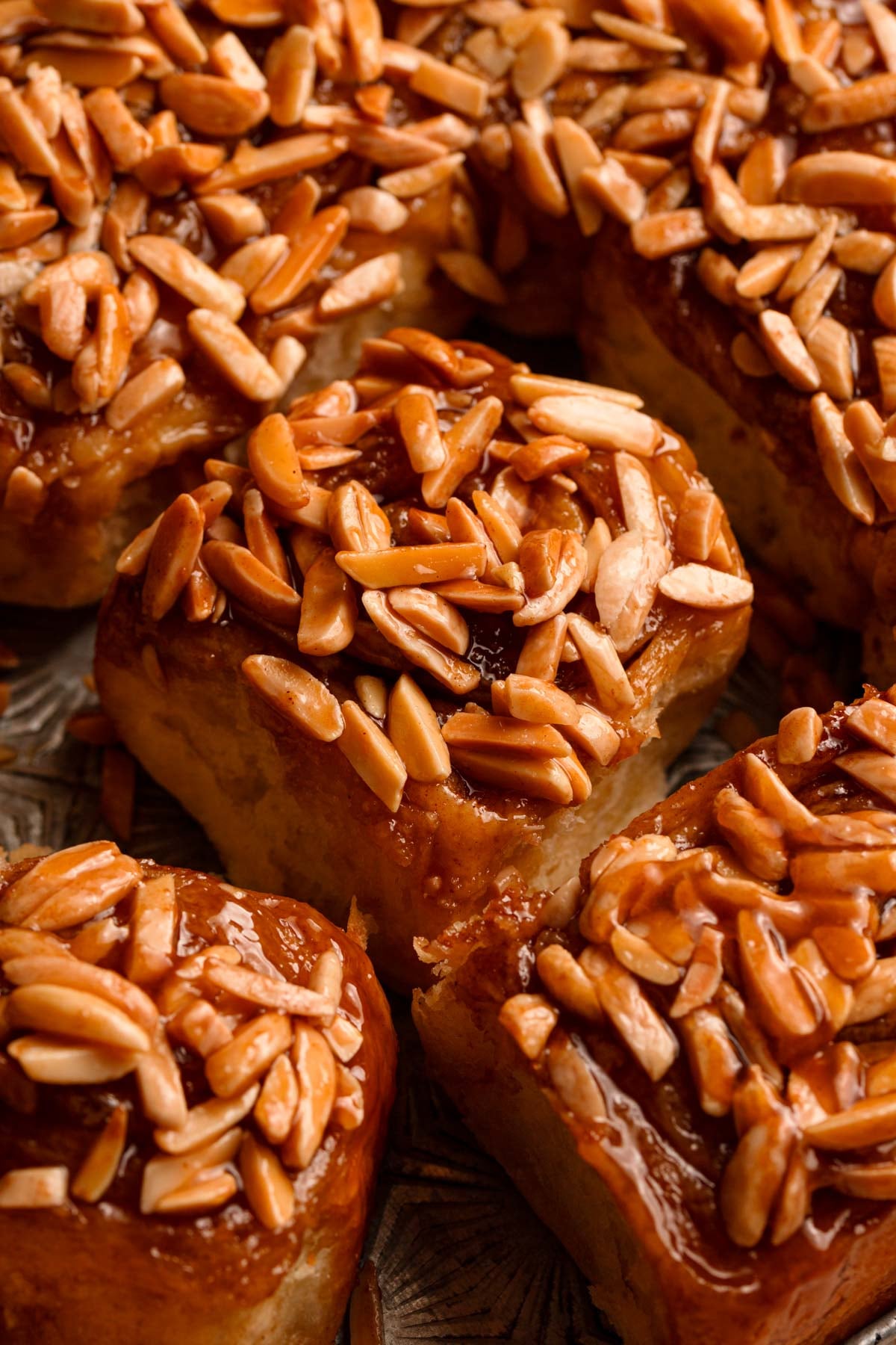 Sticky cinnamon roll topped with almonds.