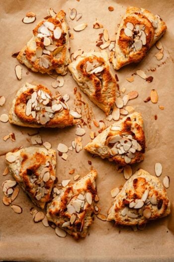 scones topped with sliced almonds and paste.