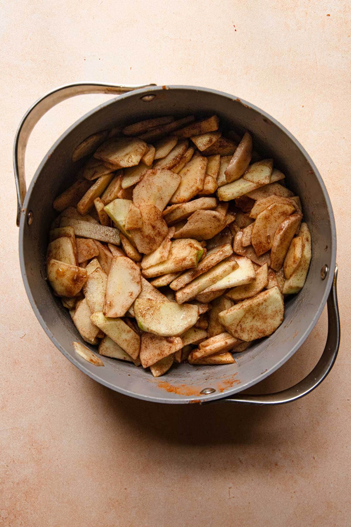 A pot with sliced apples tossed in cinnamon and sugar.