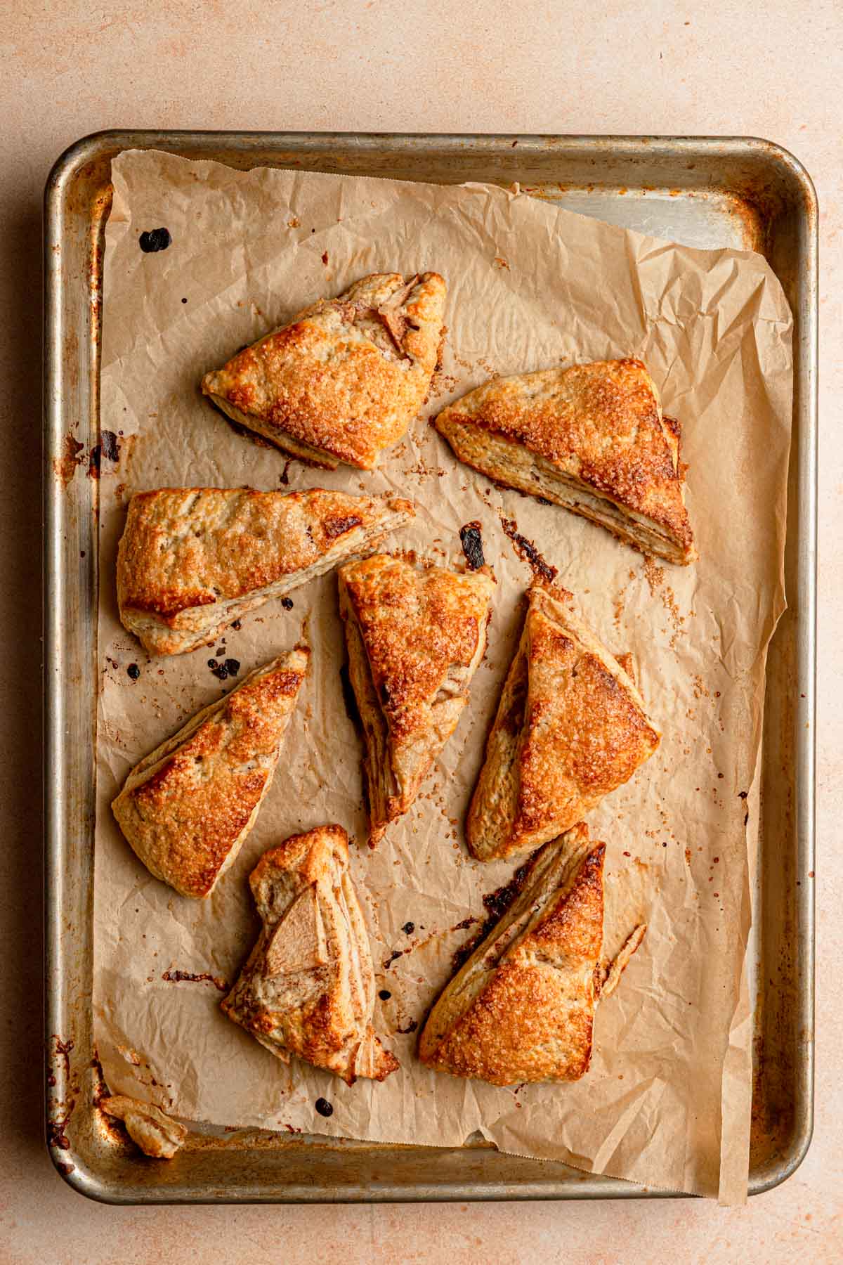Baked apple scones over a pan lined with parchment paper.